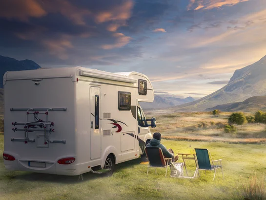 Parking caravan in front of a landscape with mountains 