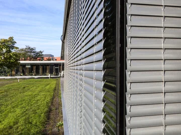Exterior view of a house with blinds and a garden 